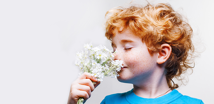Woman gently smelling a flower to model comfortable breathing depth