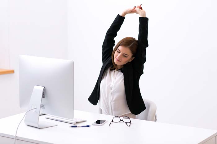 Person stretching at an office desk